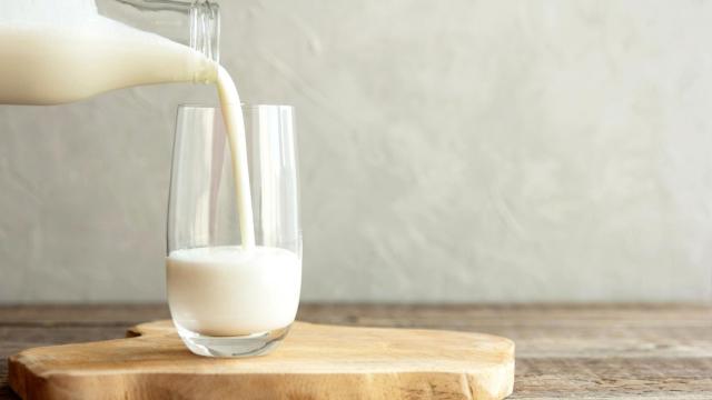 Una persona echando leche de una botella.