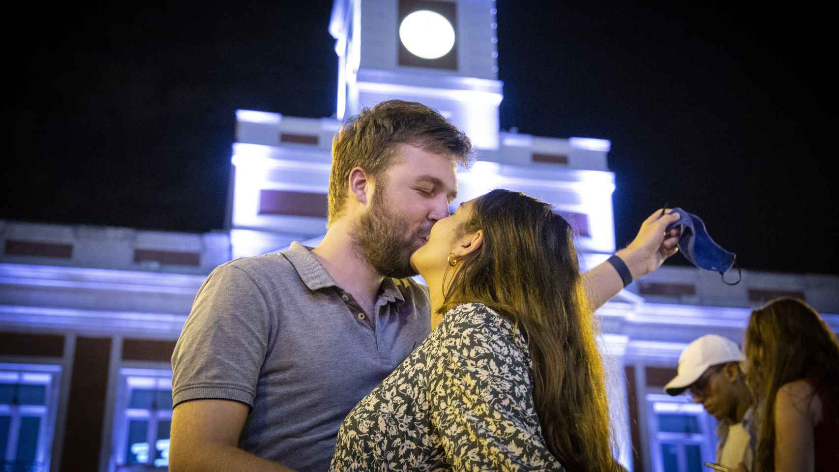 Una pareja celebra con un beso el fin de la obligación del uso de mascarillas en exteriores.