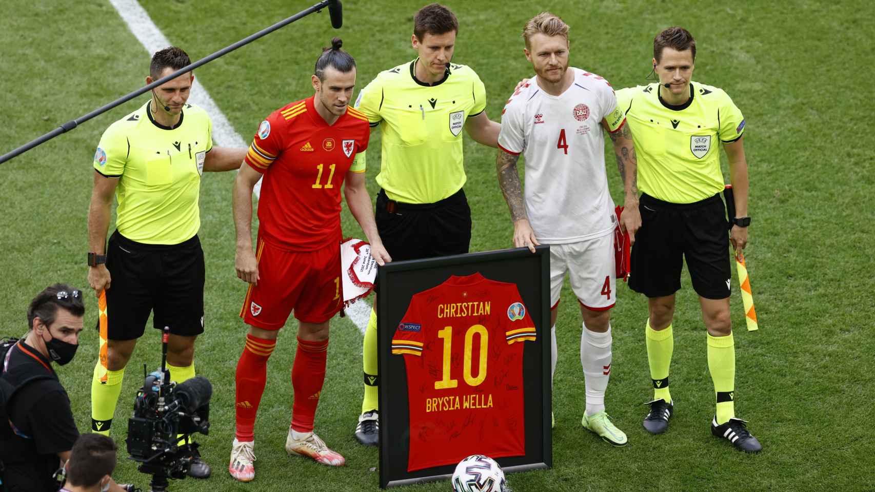 Gareth Bale, Simon Kjaer y los árbitros del Gales - Dinamarca posan con la camiseta homenaje a Eriksen