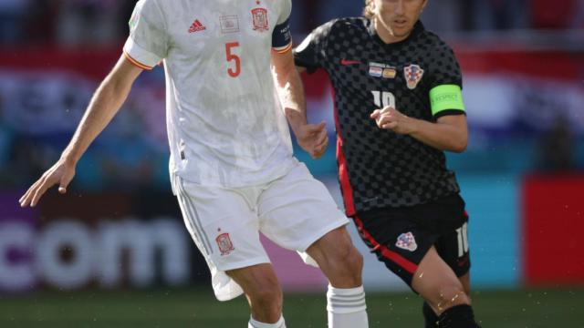 Sergio Busquets pasa en balón antes de que Luka Modric llegue a presionarle