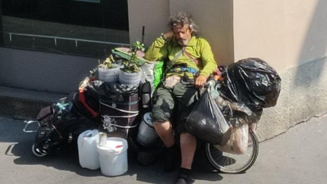 Fernando, durmiendo sobre su bicicleta en una calle de Milán.