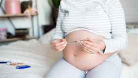 Una mujer embarazada con los aparatos para medir su nivel de glucosa y dosis de insulina.