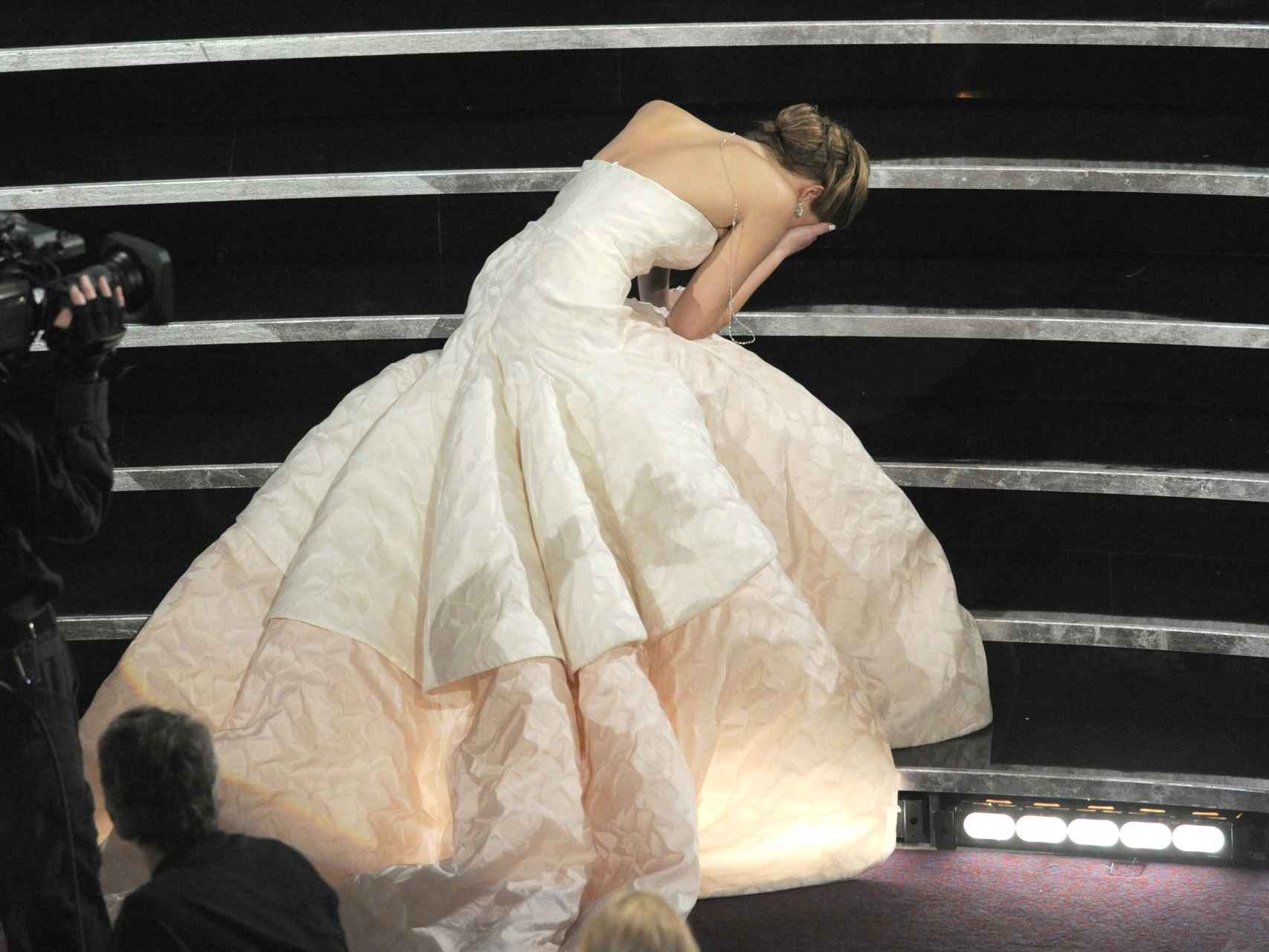 Jennifer Lawrence tropezó con su vestido de Dior al subir las escaleras para recoger su premio.
