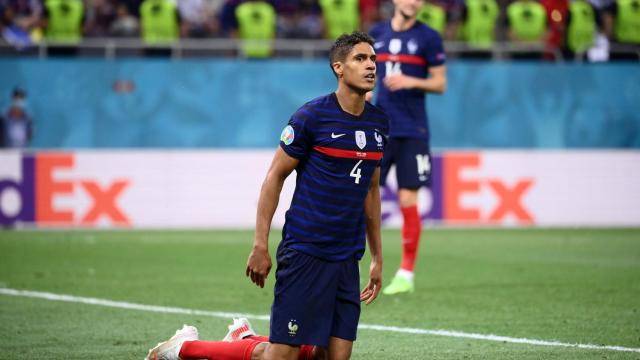 Varane, arrodillado en el césped durante un partido de Francia