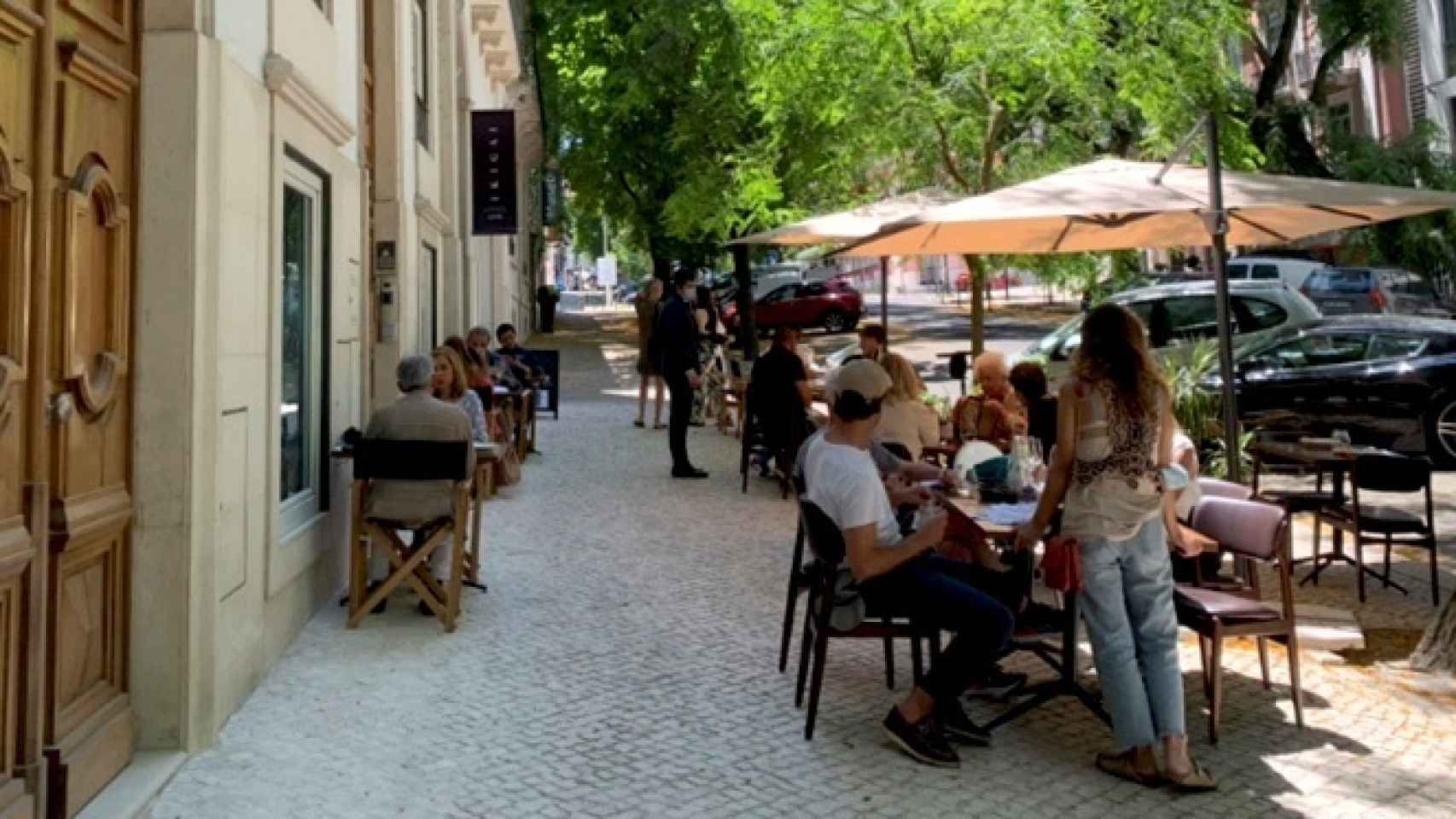 Varias personas consumen en una terraza en Lisboa, Portugal.