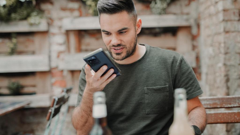 Un hombre mirando su teléfono móvil.