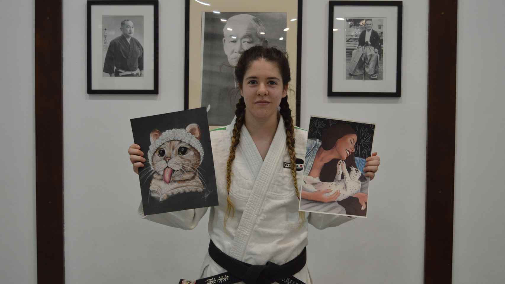Sandra López posando en el dojo con sus retratos.