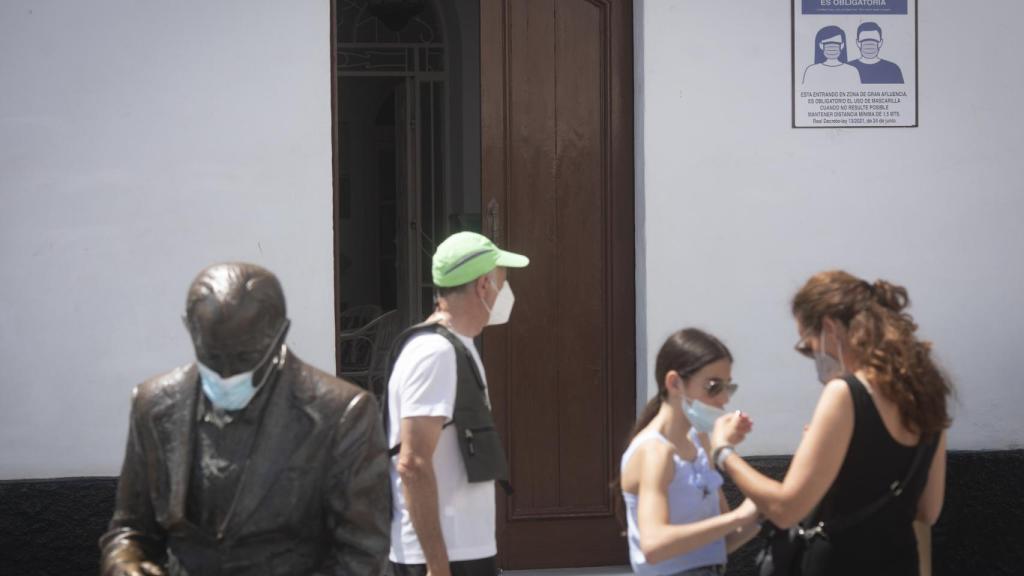 Una familia, con mascarilla, pasea por el centro del pueblo