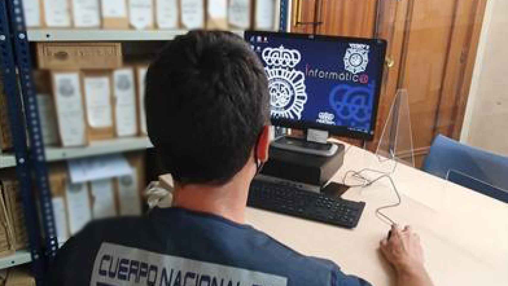 Un agente de la Policía Nacional delante de su ordenador.