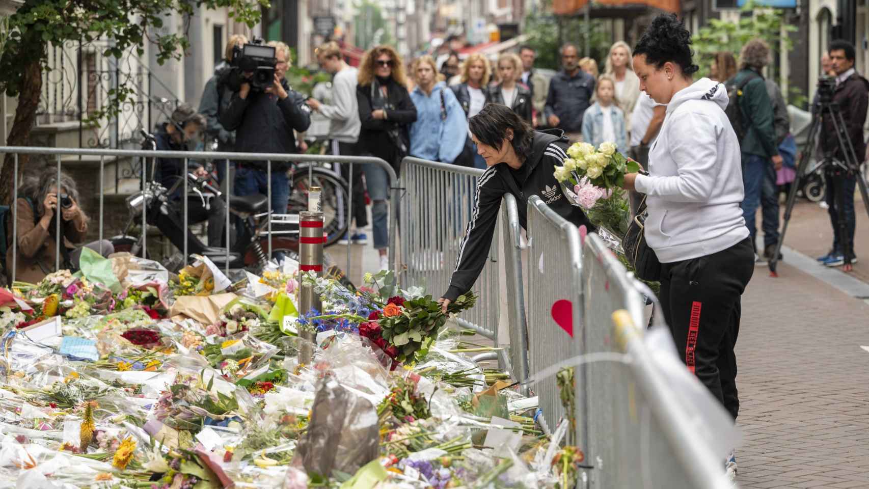 Personas dejando flores en honor al periodista fallecido.