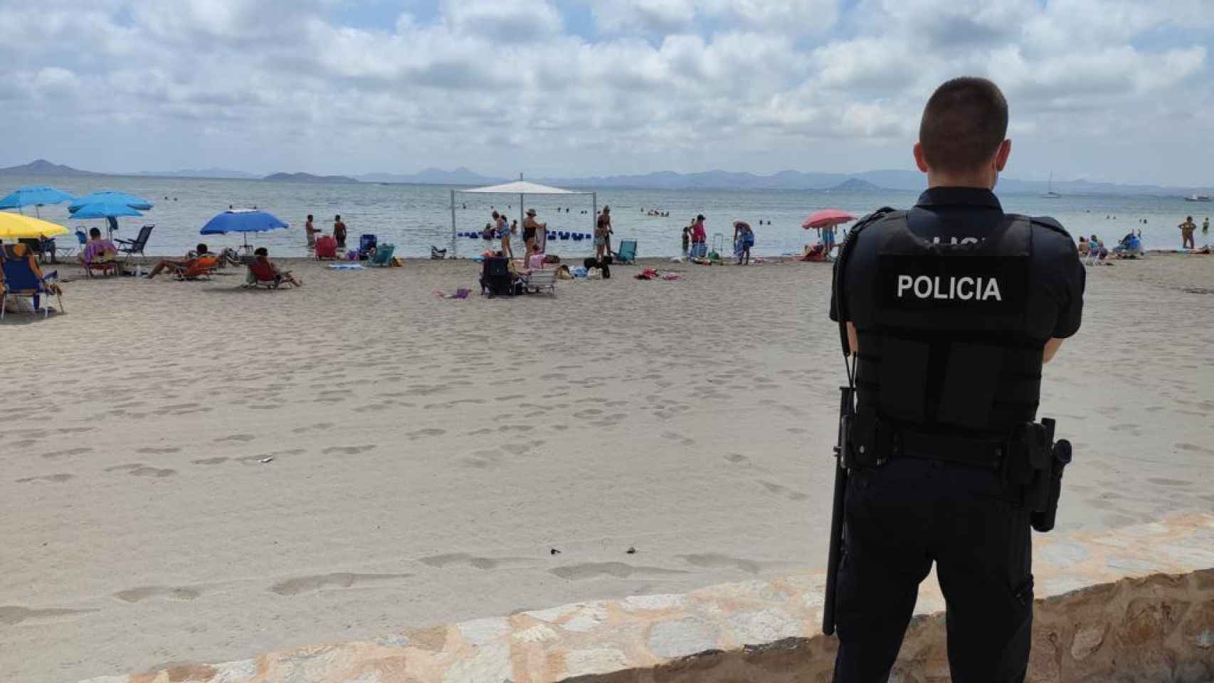 Un policía local de Los Alcázares frente a la zona de playa donde se ahogó el niño.