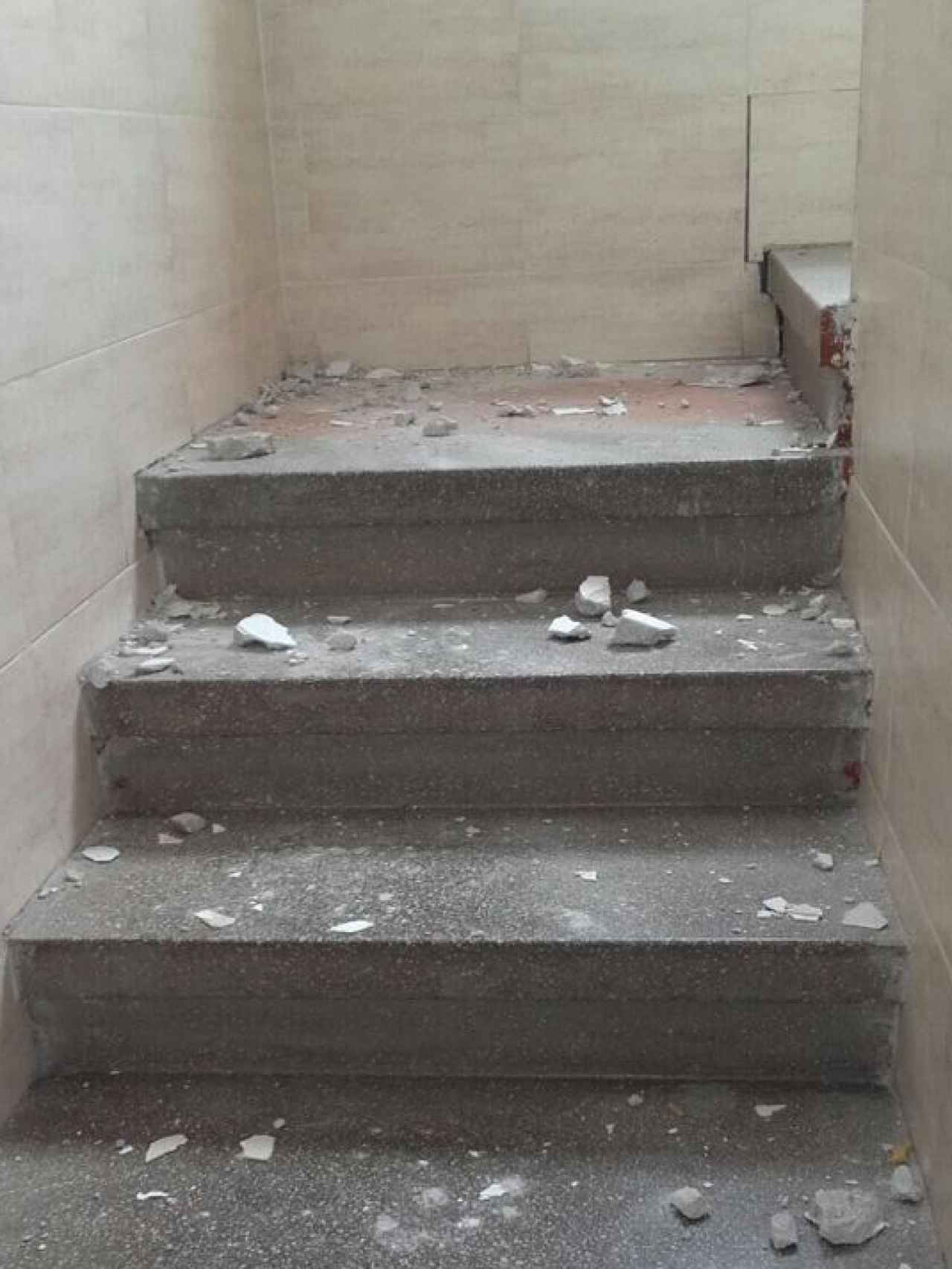 Restos de escombros caídos en la escalera de uno de los edificios de Carranque.
