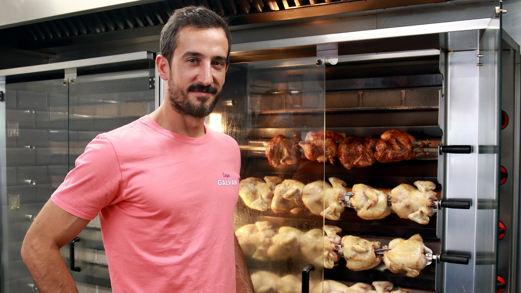 Rubén Galván, tercera generación a cargo de los asadores Casa Galván, posa con los pollos más exitosos de Madrid.