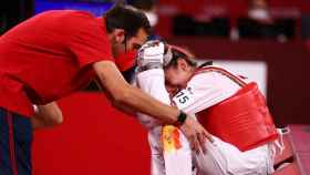 Adriana Cerezo, consolada por su entrenador tras perder en la final olímpica frente a Panipak Wongphatthanakit