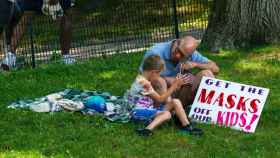 Un padre y un hijo, en Central Park, durante la manifestación contra las vacunas en Nueva York.