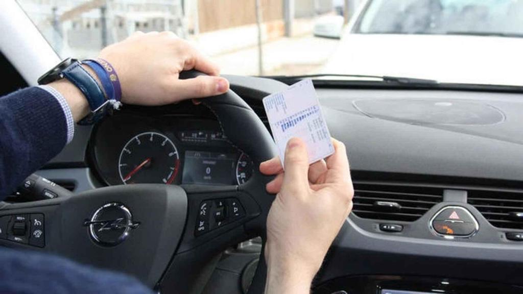 Un conductor sujeta su carné de conducir.