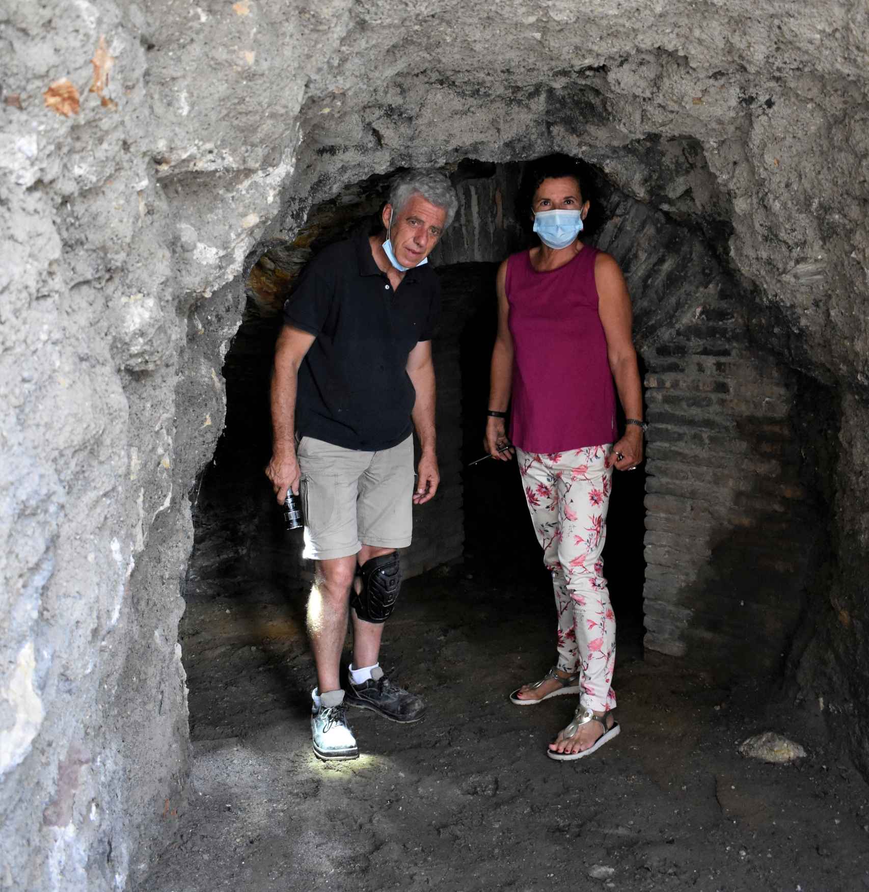 La arqueóloga Fanny de Carranza y el operario Alfonso Gómez, linterna en mano, a la entrada del refugio.