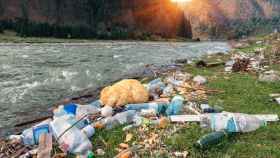 Residuos plásticos a la orilla de un río.
