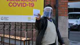Una persona muestra su carnet de vacunación luego de salir de un centro de inmunización, en el barrio La Boca en Buenos Aires.