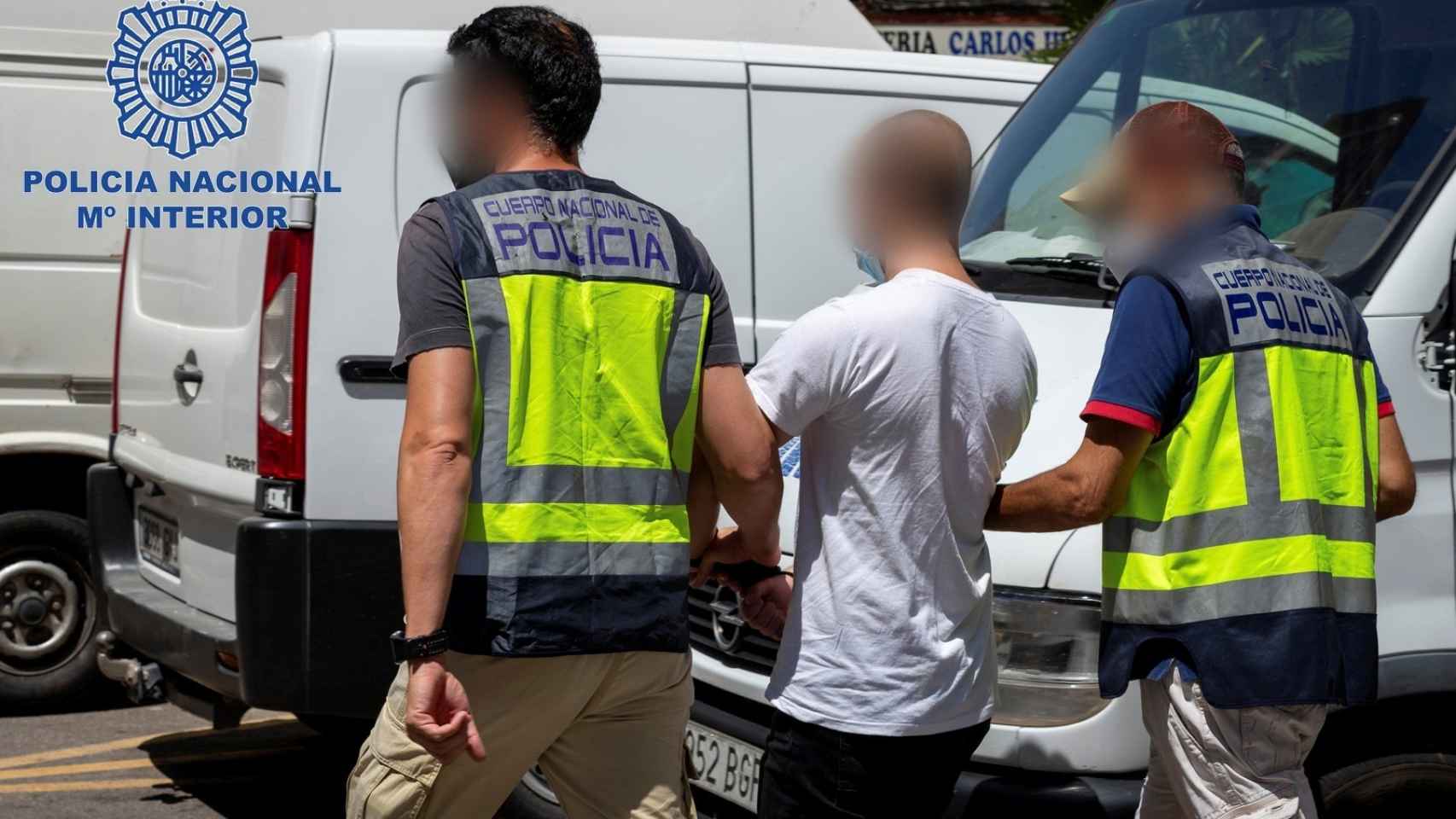 Dos policías escoltan a un joven neonazi de 20 años tras su detención en Cartagena como presunto autor.