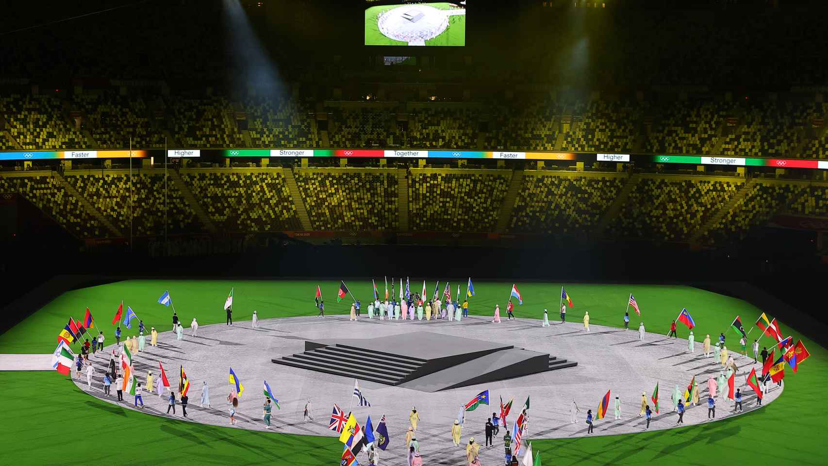 Las banderas de cada país colocándose en el centro del estadio de Tokio 2020