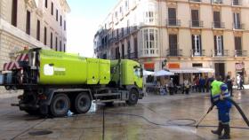 Un operario de Limasam baldea una calle en el Centro de Málaga.