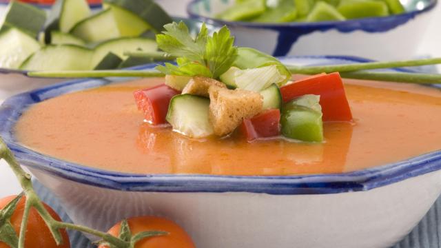 Un gazpacho con trozos de pan, pepino y tomate.