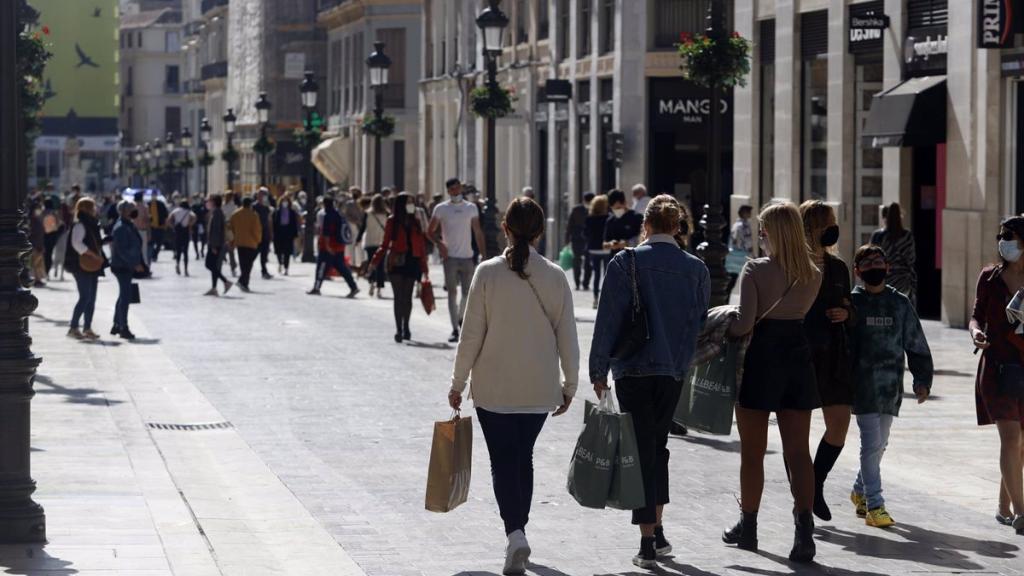 Personas comprando por calle Larios.