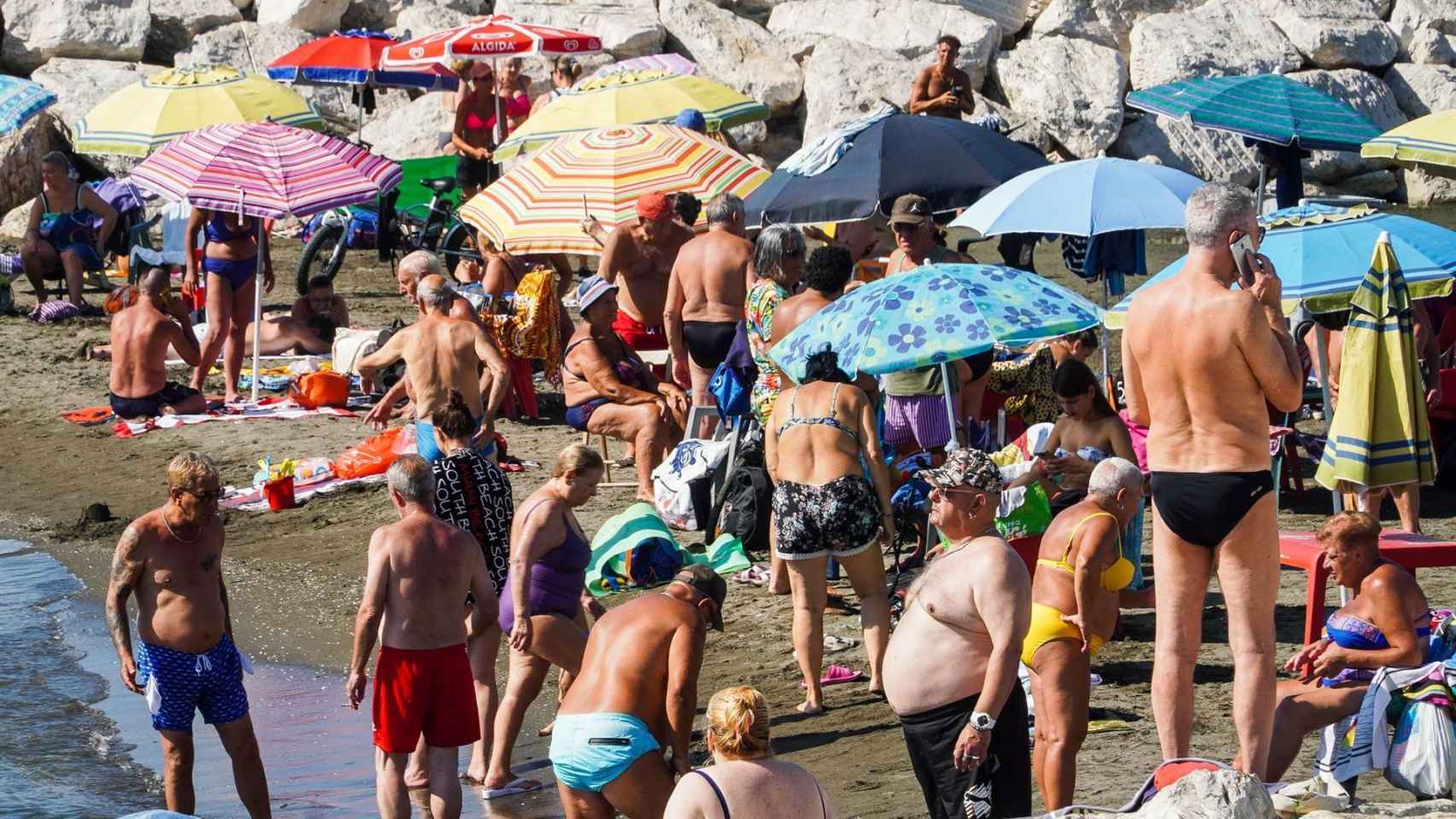 Varios veraneantes disfrutan de una jornada en la playa en Nápoles (Italia).