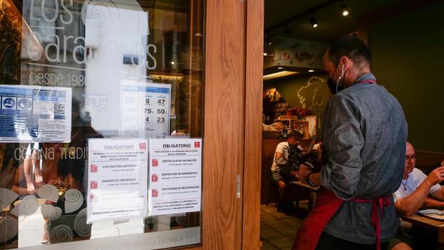 Carteles de indicaciones de obligatoriedad de presentar certificados antes de acceder al interior en un local de Santiago de Compostela.