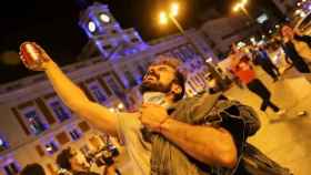 Un hombre brinda por el fin del estado de alarma en la Puerta del Sol de Madrid.