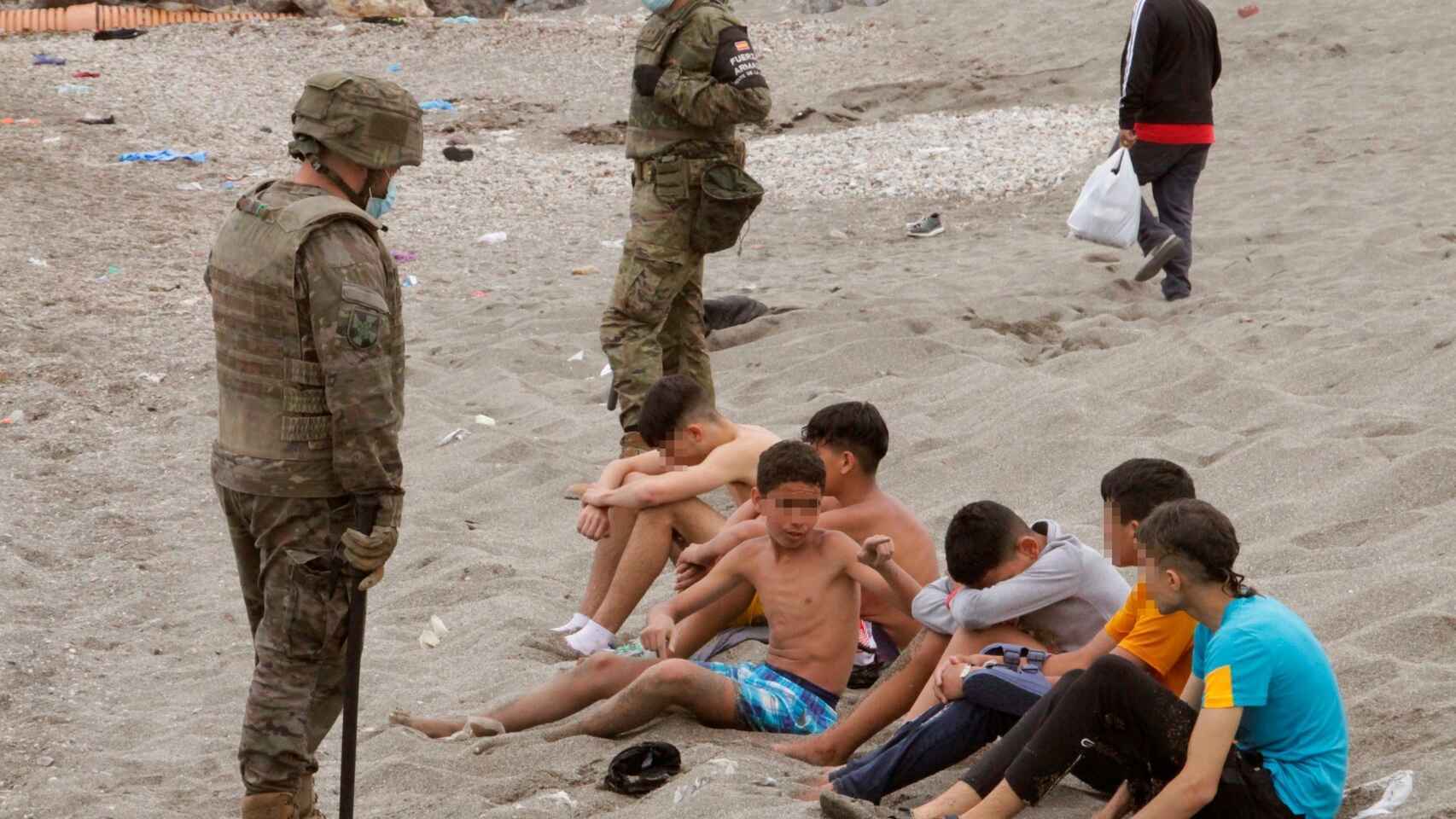 Varios menores llegados a Ceuta custodiados por militares.