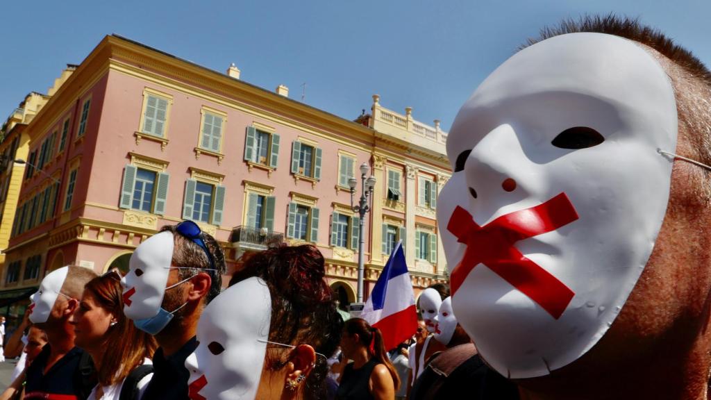 Manifestantes antivacunas enmascarados.