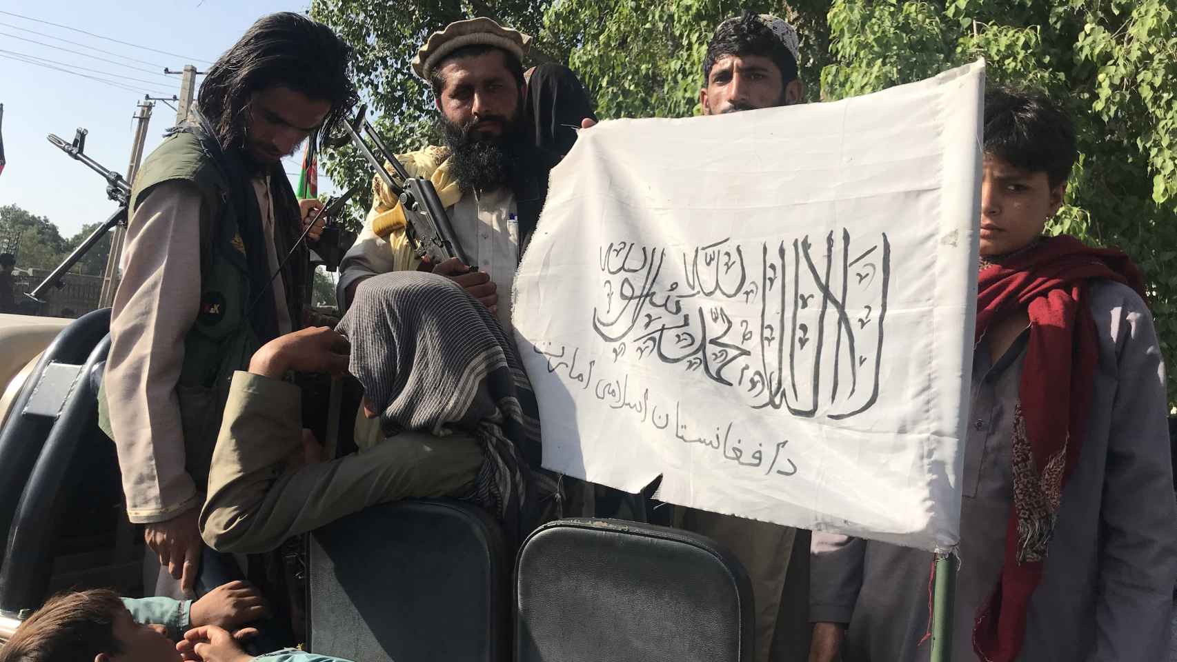 Soldados talibanes con su bandera.