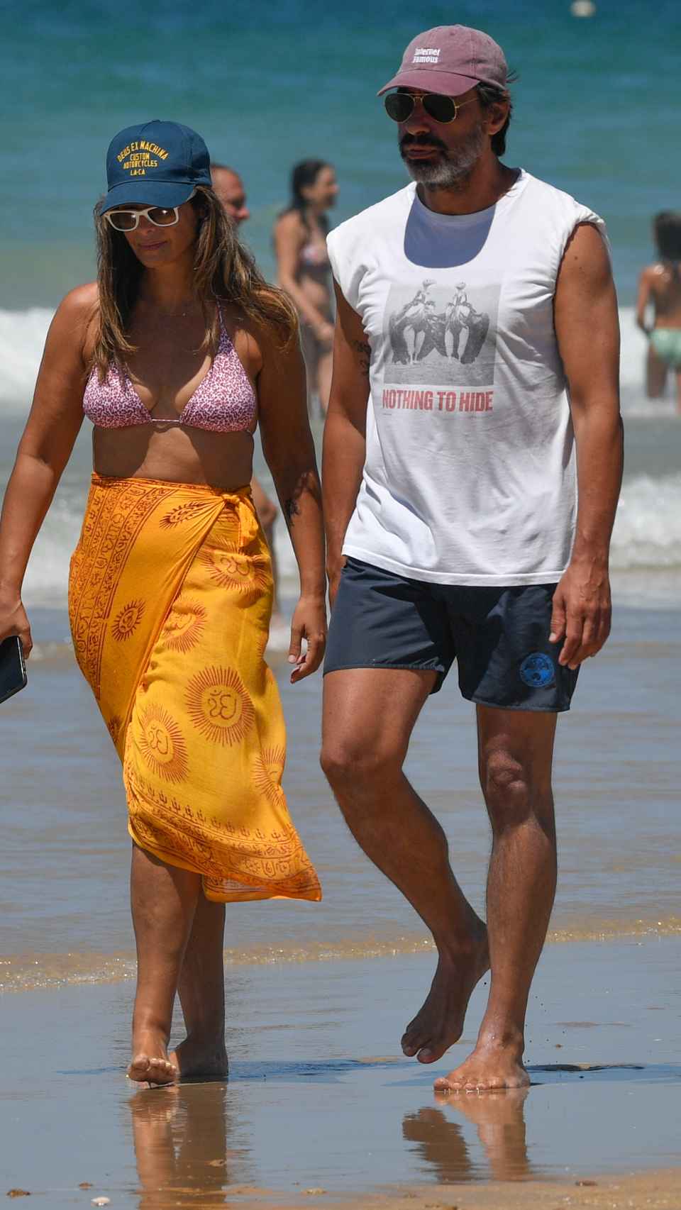 Nuria Roca y Juan del Val paseando por la orilla de la playa.
