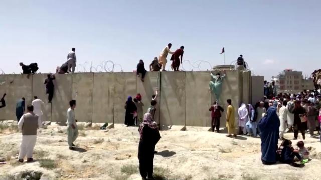 Un grupo de personas intentando acceder al aeropuerto de Kabul.