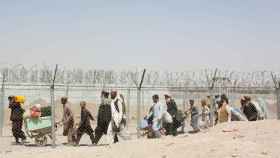 Un grupo de personas atraviesa la valla que separa Afganistán de Pakistán en la ciudad de Chamán.