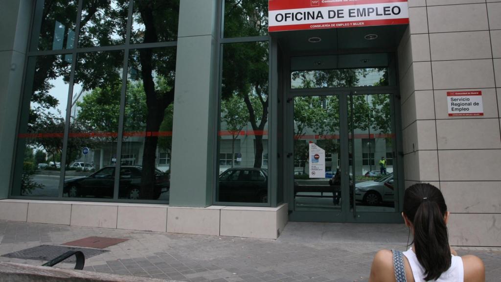 Una joven ante una oficina de empleo.