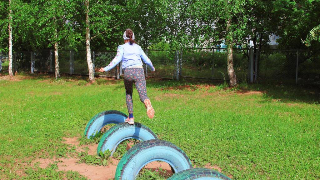 Una niña salta sobre neumáticos en una foto de archivo.