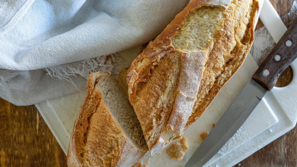 Una barra de pan blanco cortada por la mitad.