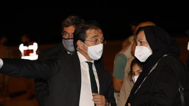 José Manuel Albares, conversando con una refugiada afgana en la base aérea de Torrejón.