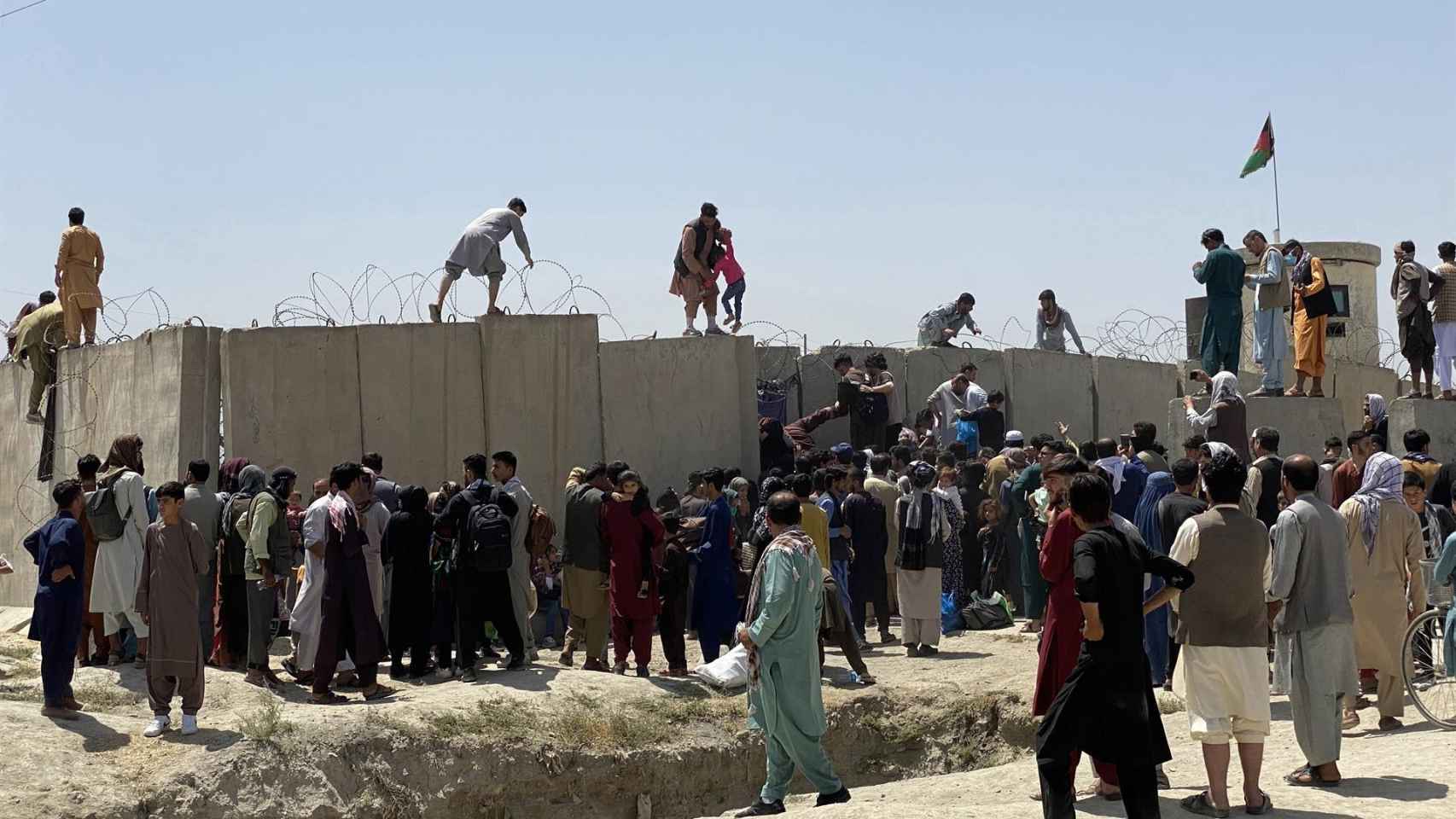 Ciudadanos afganos intentan saltar los muros del aeropuerto de Kabul. Lo que se vivió en agosto fue un caos absoluto.