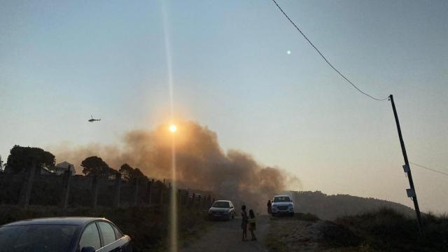 Un helicóptero trata de apagar el fuego declarado en Razo, en Carballo.