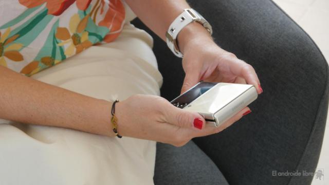 UNa mujer viendo uns SMS en la pantalla externa del  Samsung Galaxy Z Flip 3