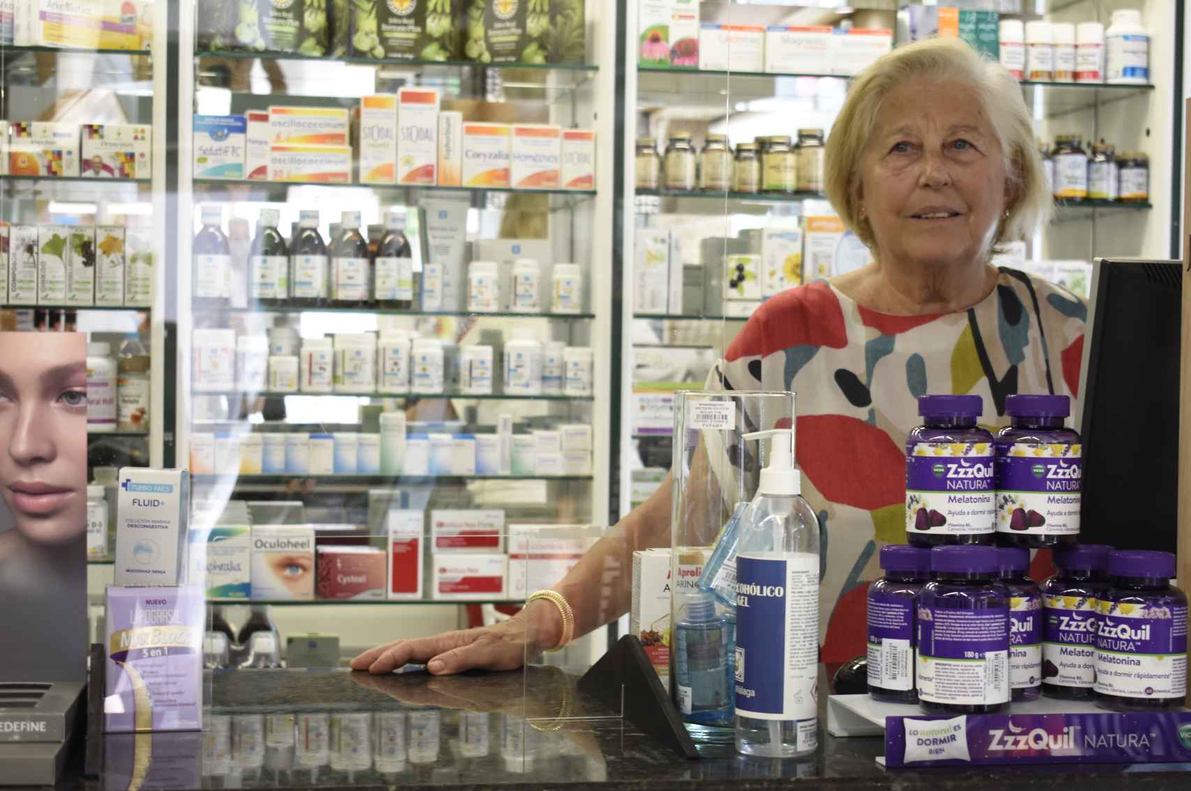 María frente al mostrador de su farmacia.