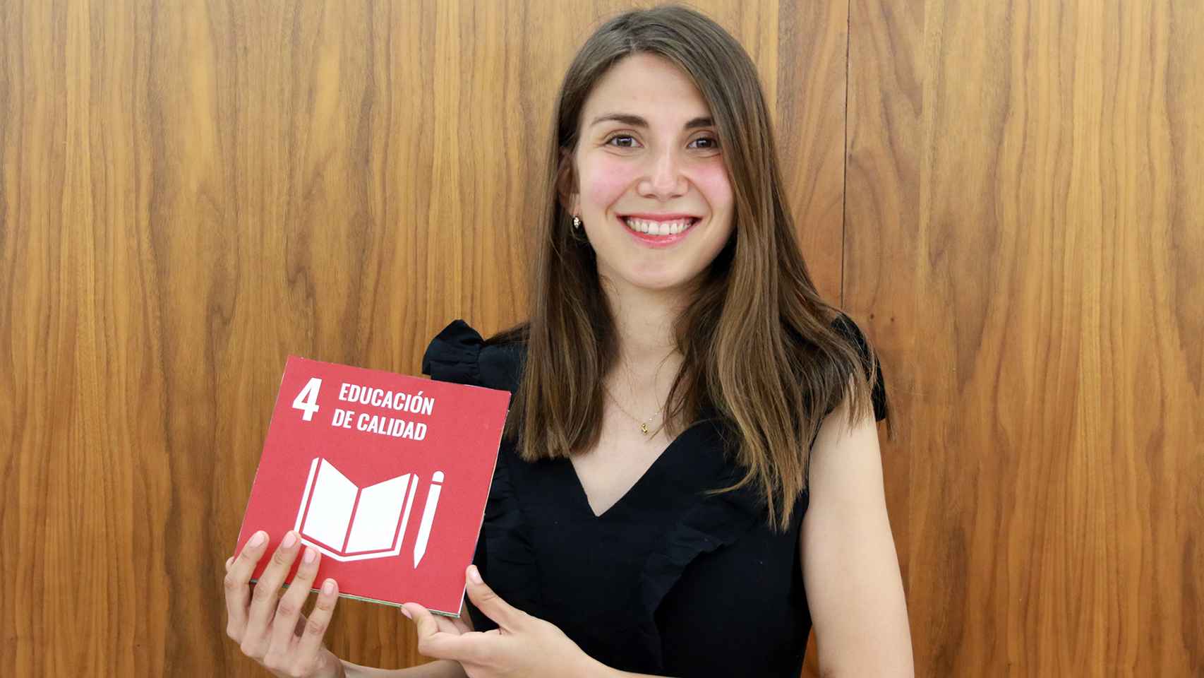 Irene Larriba sujeta el cartel del Objetivo de Desarrollo Sostenible número 4 sobre educación de calidad.