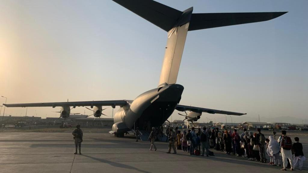 Un grupo de refugiados afganos embarca en un avión A400M del Ejército español en el aeropuerto de Kabul.