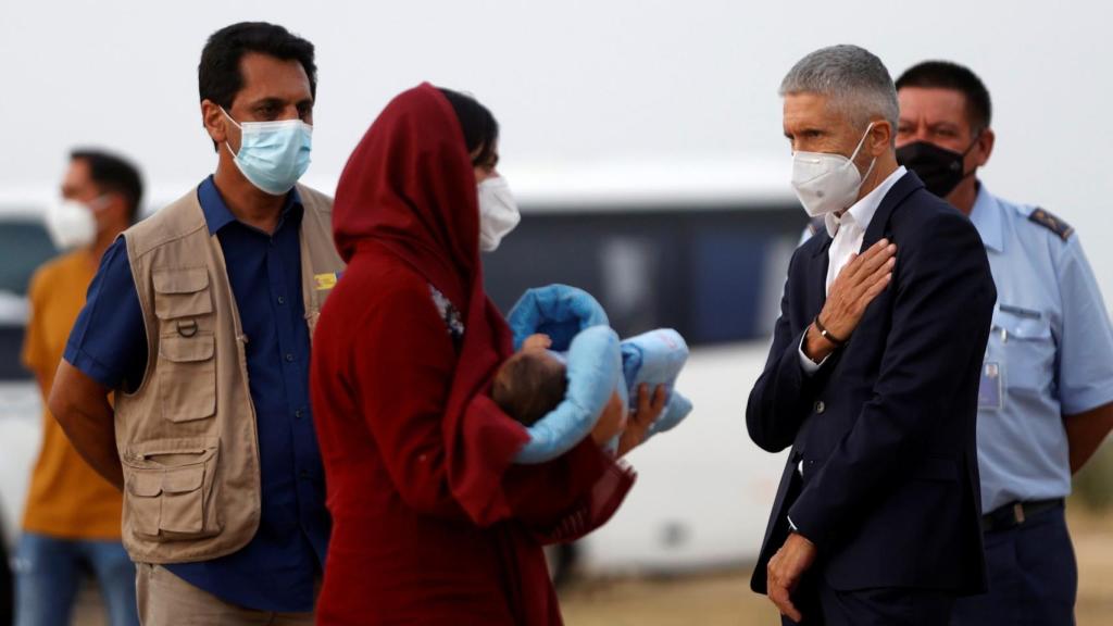 El ministro del Interior, Fernando Grande Marlaska saluda a una mujer afgana y a su bebé evacuados de Kabul, en la base de Torrejón.