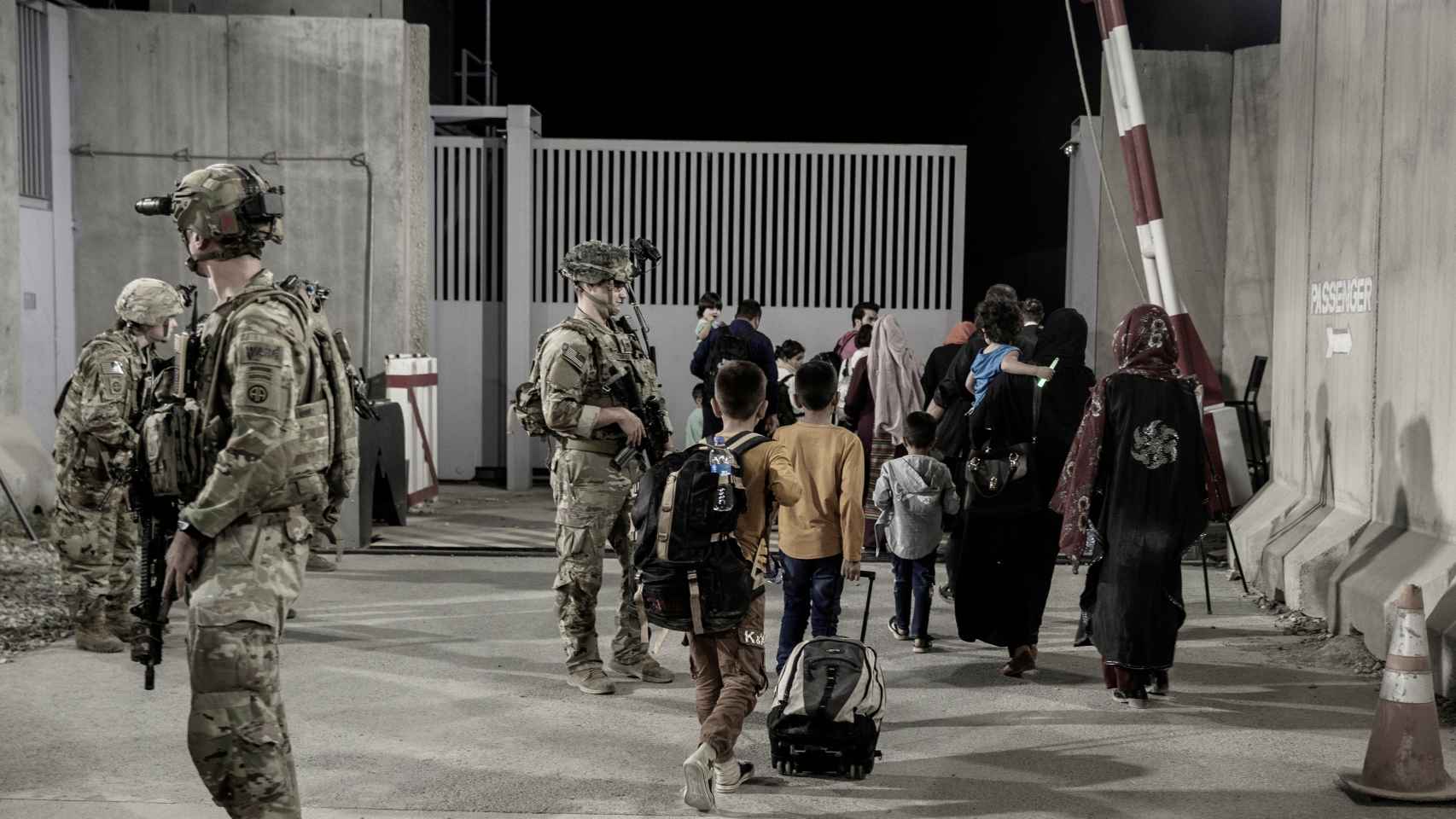 Marines estadounidenses metiendo a ciudadanos afganos en el aeropuerto de Kabul.