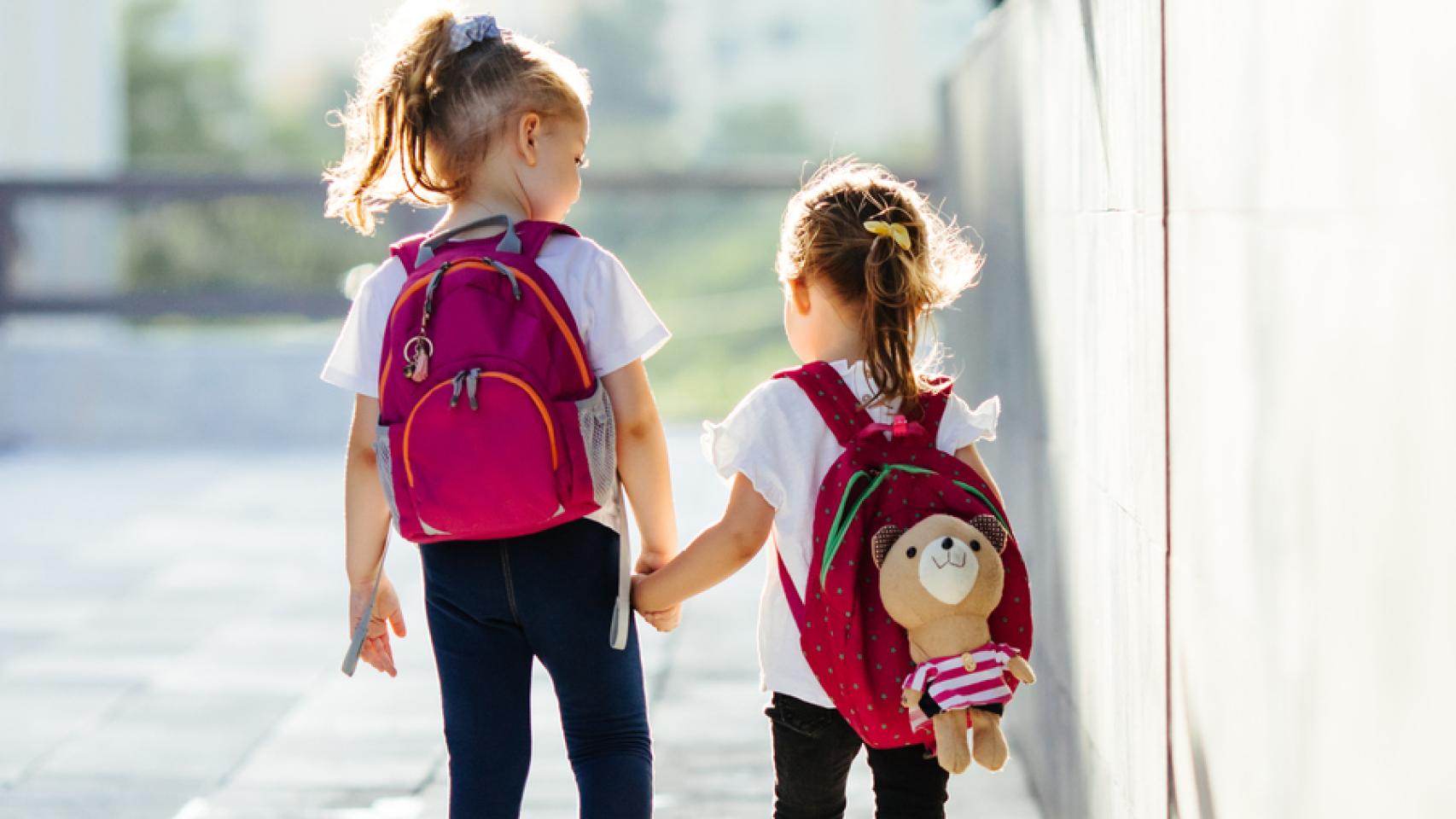 Dos niñas se dan la mano.